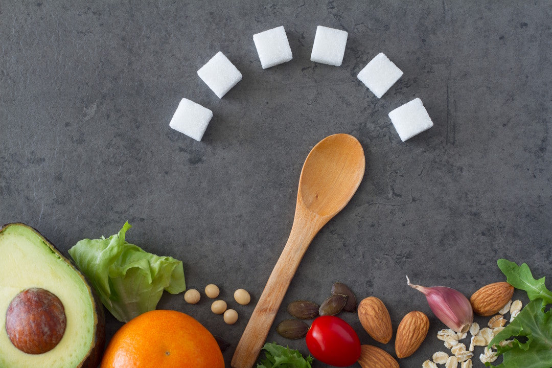 Holzlöffel zeigt auf Zuckerwürfel, die wie ein Tacho angeordnet sind