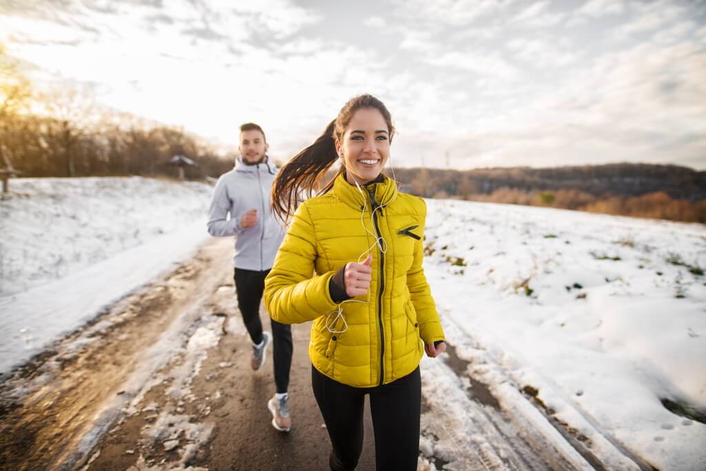 Frau und Mann joggen im Winter