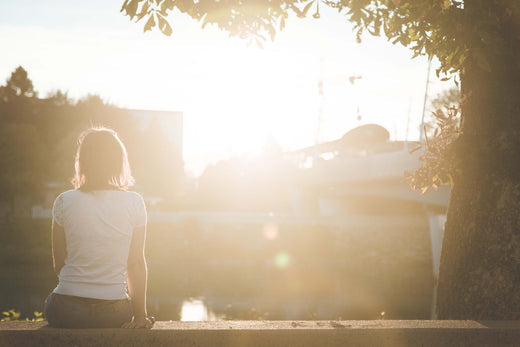 Frau sitzt in der Sonne und tankt Vitamin D