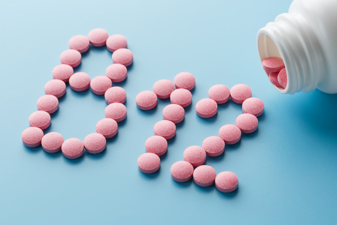 Rosa Tabletten formen den Schriftzug "B12"
