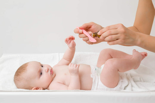 Mutter verabreicht Ihrem Baby Vitamin-D-Tropfen
